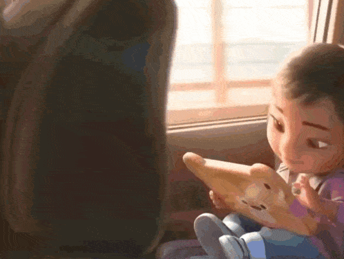 a little girl is sitting in a car looking at a cell phone