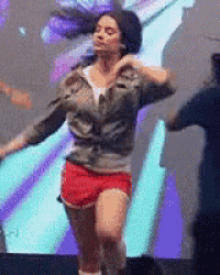 a woman is dancing on stage in front of a large screen .