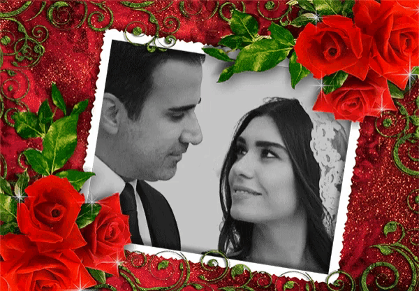 a black and white photo of a man and woman with red roses around them