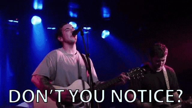 a man singing into a microphone with the words " do n't you notice " written below him