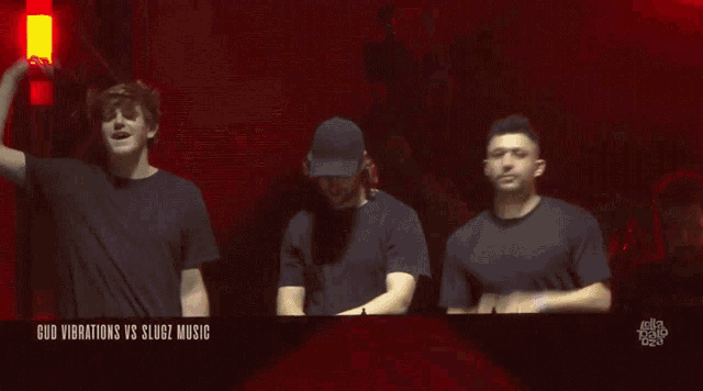 three men are dancing in front of a screen that says god vibrations vs slug2 music