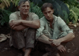 two men are sitting next to each other with their arms crossed