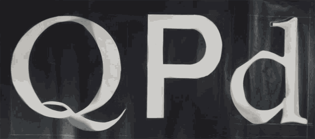 the letters q and p are cut out of a sheet of paper