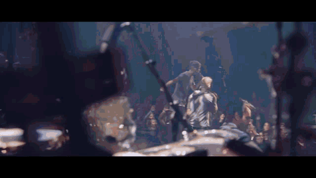 a group of people are dancing on a stage in front of a microphone .