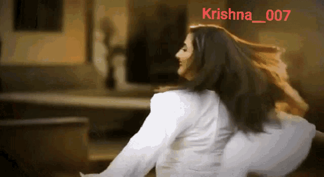 a woman in a white shirt is dancing with the name krishna 007 on the bottom