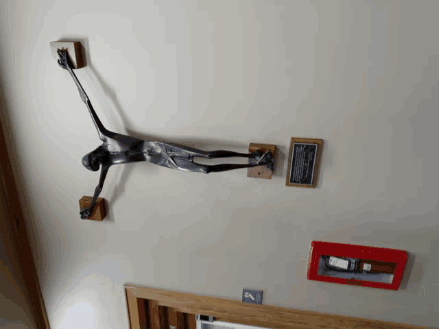 a statue of a man hanging from a cross on a wall