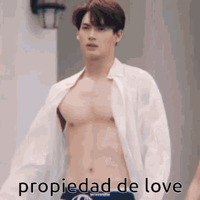 a shirtless man in a white shirt and blue underwear is standing in front of a building .