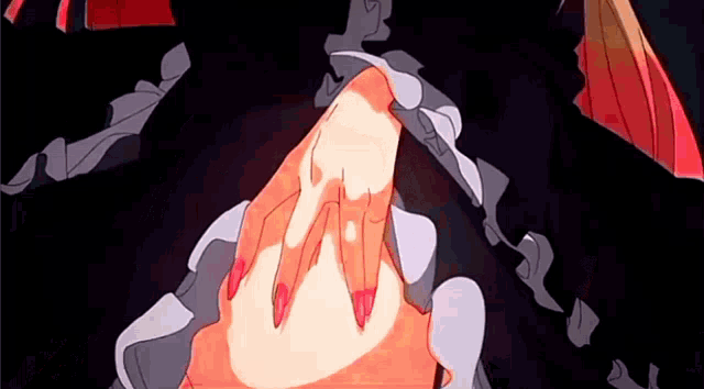 a close up of a woman 's hand with long red nails .