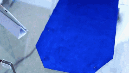a blue piece of fabric is pinned to a glass surface
