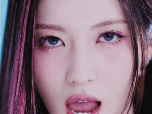 a close up of a woman 's face with her tongue hanging out
