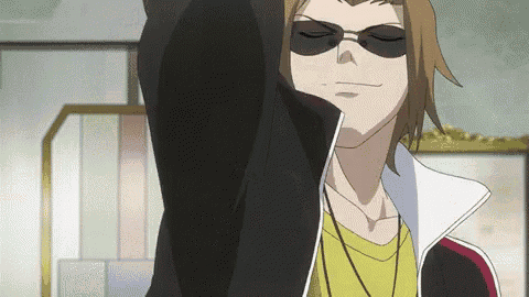 a man wearing sunglasses and a yellow shirt holds his arm up in the air