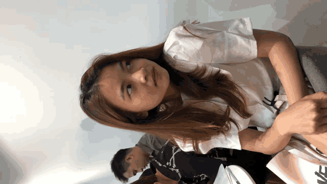 a woman wearing a white shirt with the letter n on the front