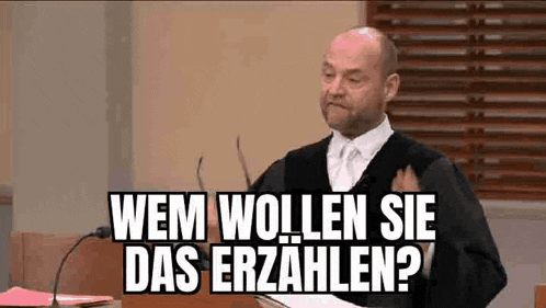 a man in a judge 's robe is giving a speech in a courtroom while holding a book .