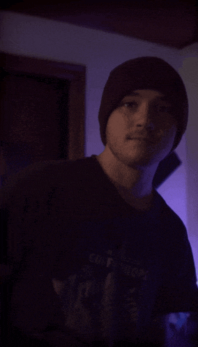 a man wearing a beanie and a t-shirt that says ' comm troops ' on it