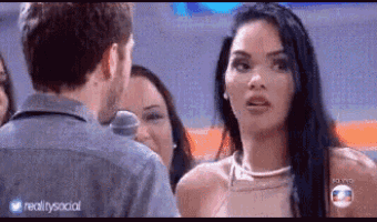 a man and a woman are talking to each other in front of a group of people .