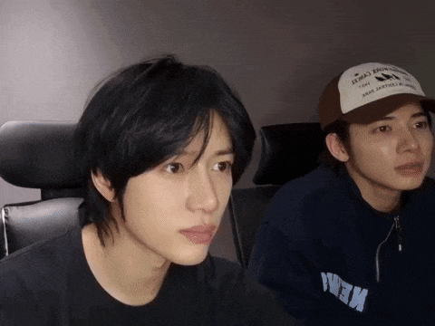 two young men are sitting next to each other and one of them is wearing a baseball cap that says ' army '