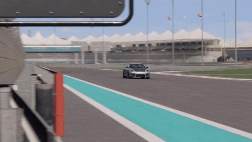 a car is driving down a race track with a blue stripe