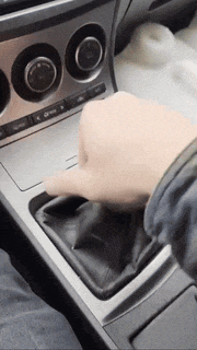 a close up of a person 's hand on the shifter of a car