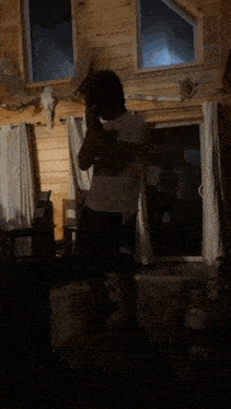 a man is dancing in a living room with a bottle of water in front of him