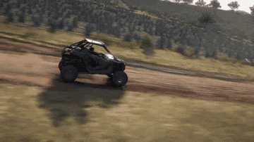 a atv is driving down a dirt road in a video game