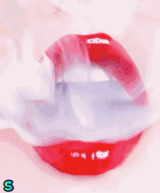 a close up of a woman 's red lips with smoke coming out of it .