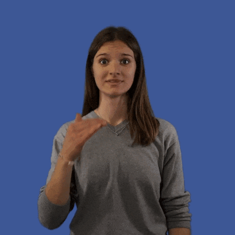 a woman in a grey sweater is making a funny face