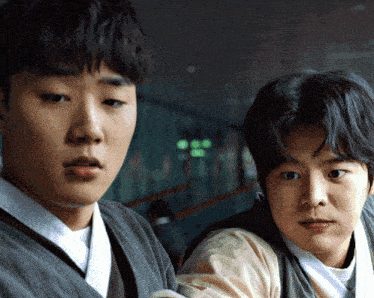 two young men are standing next to each other and one has a bandage on his arm
