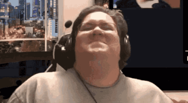 a man wearing headphones and glasses looks up at the camera