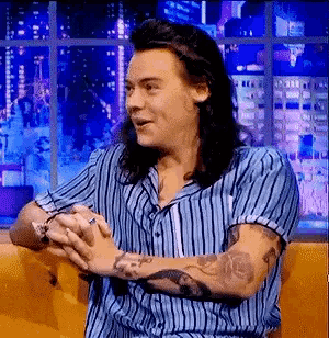 harry styles is wearing a blue and white striped shirt
