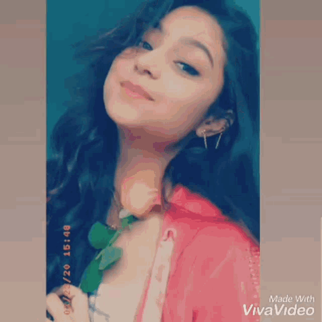 a girl is holding a rose in her hand and smiling .
