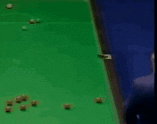 a man in a suit is playing pool on a green table .