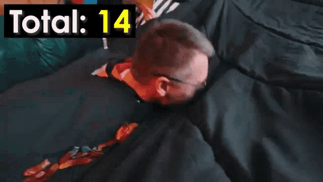 a man wearing sunglasses is sitting on a couch with the words total 14 above him