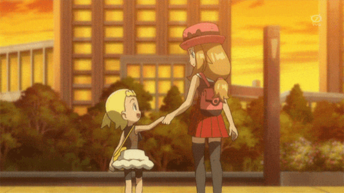 a girl in a red hat holds the hand of a little girl in a white dress