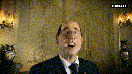 a man in a suit and tie is standing in front of a wall with canal + written on it