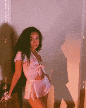 a woman wearing a pink top and shorts is standing in front of a kodak film