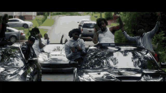 a group of men are standing in front of a car