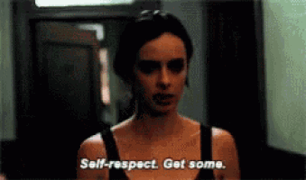 a woman in a black tank top is standing in a hallway and says self respect get some .
