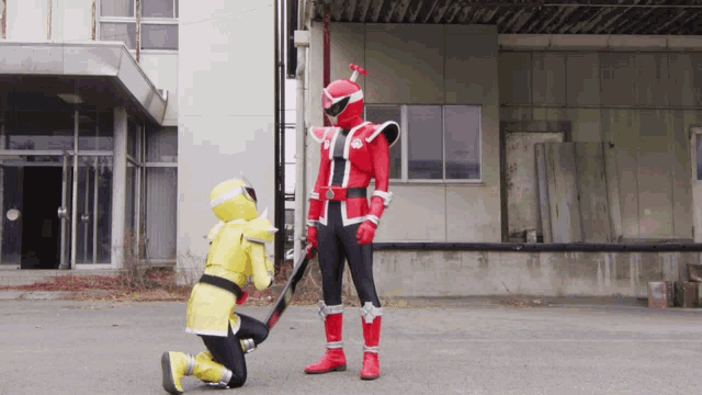 a man in a red and yellow costume is kneeling down next to a man in a yellow costume
