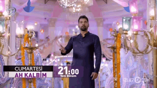 a man in a blue shirt is standing in front of a sign that says 21:00