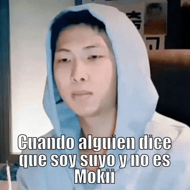 a man wearing a white hoodie with the words cuando alguien dice que soy suyo y no es mokii