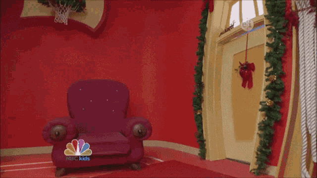 a man standing in front of a christmas tree with nbc kids written on the bottom