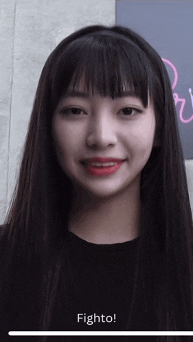 a girl with long black hair and red lipstick is smiling and says fight to