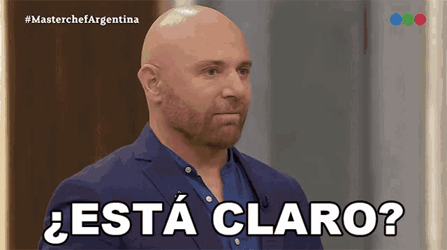 a bald man with a beard says " esta claro " in spanish