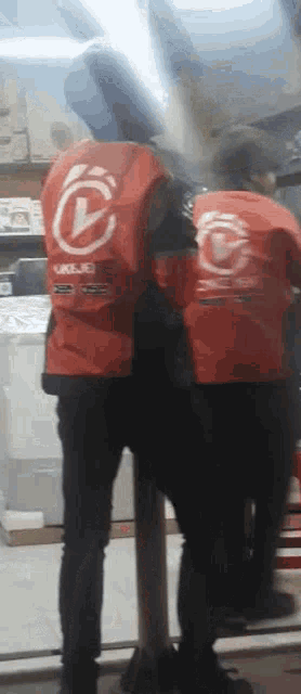 a man wearing a red vest that says ' ukg ' on it