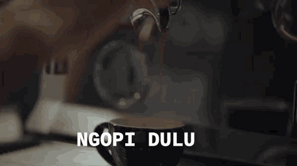 a cup of coffee is being poured from a coffee maker with the words ngopi dulu below it