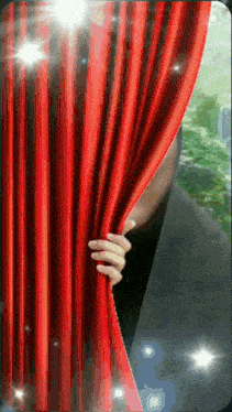 a hand is peeking through a red curtain with sparkles coming out of it