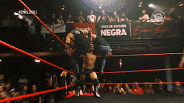 two wrestlers are in a ring with a sign that says negra
