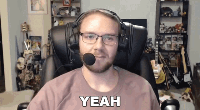 a man wearing headphones and glasses says yeah