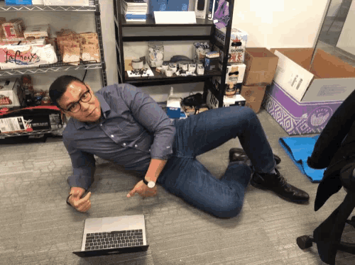 a man laying on the floor in front of a shelf with a box that says legacy