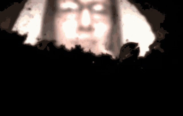 a blurred image of a person 's face with a light shining on it